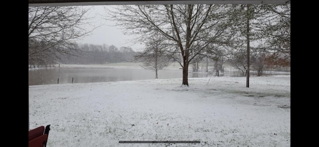 yard covered in snow with a water view