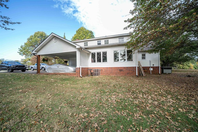 rear view of house featuring cooling unit, a lawn, and a carport