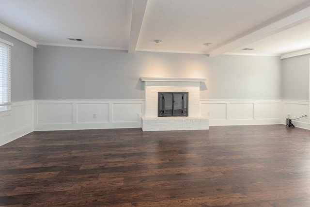 unfurnished living room with dark hardwood / wood-style flooring, crown molding, beam ceiling, and a brick fireplace