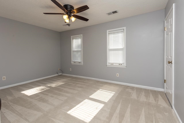 empty room with light carpet, a textured ceiling, and ceiling fan