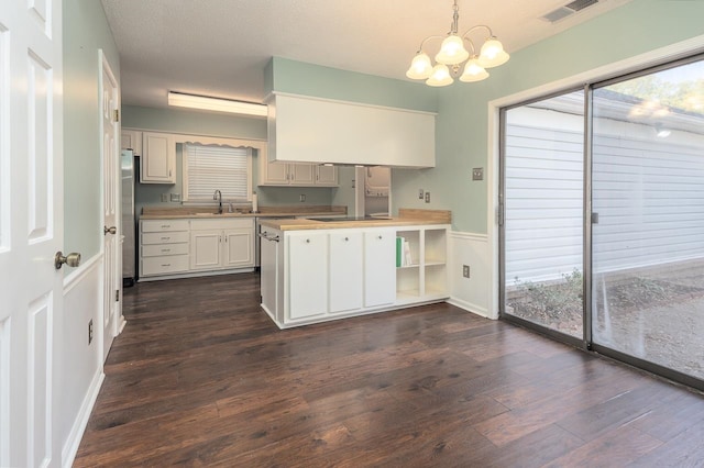 kitchen featuring dark hardwood / wood-style floors, decorative light fixtures, a chandelier, white cabinets, and a textured ceiling