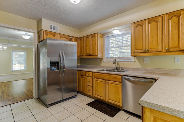 kitchen featuring light wood-type flooring, stainless steel appliances, sink, and a wealth of natural light