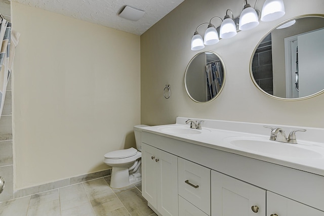 bathroom featuring toilet, a textured ceiling, vanity, and tile patterned floors