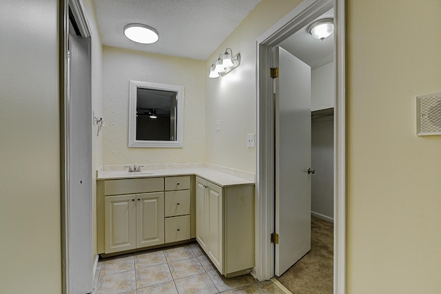 bathroom featuring vanity, a textured ceiling, and tile patterned floors