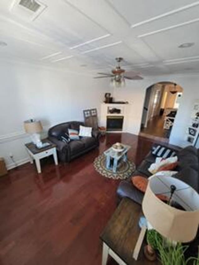 living room with dark wood-type flooring and ceiling fan