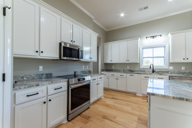 kitchen featuring white cabinetry, crown molding, and appliances with stainless steel finishes