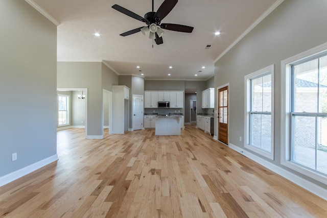 unfurnished living room featuring crown molding, light hardwood / wood-style floors, and a healthy amount of sunlight