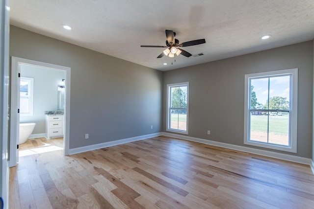 empty room featuring light hardwood / wood-style floors, a textured ceiling, and ceiling fan