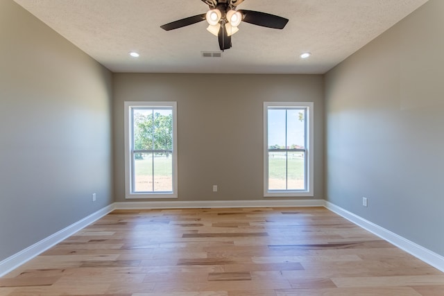 spare room featuring light hardwood / wood-style floors, a textured ceiling, and ceiling fan