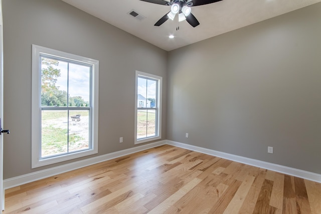 spare room featuring light hardwood / wood-style flooring, a healthy amount of sunlight, and ceiling fan