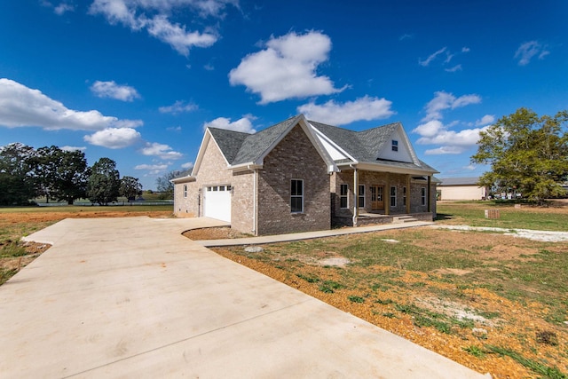 view of front of house featuring a front yard, a garage, and covered porch