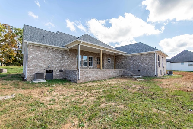 rear view of house featuring a lawn and central AC unit