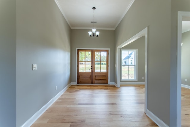 doorway with french doors, ornamental molding, an inviting chandelier, and light wood-type flooring