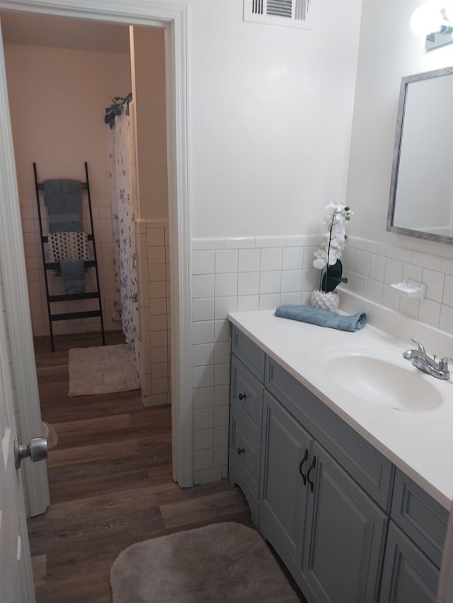 bathroom featuring vanity, hardwood / wood-style floors, and tile walls