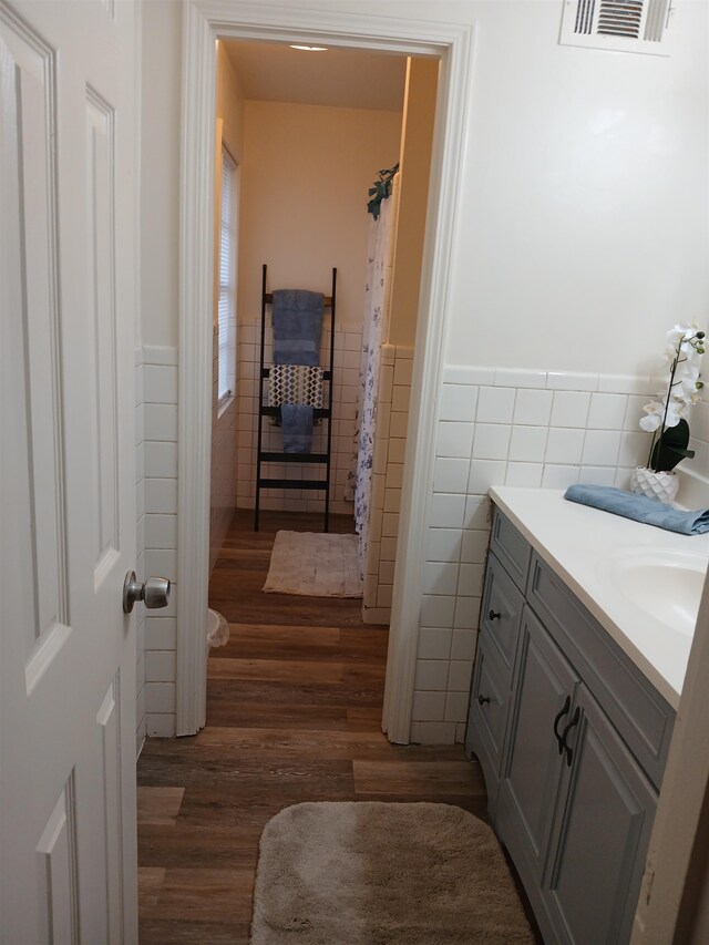 bathroom with tile walls, vanity, and hardwood / wood-style floors