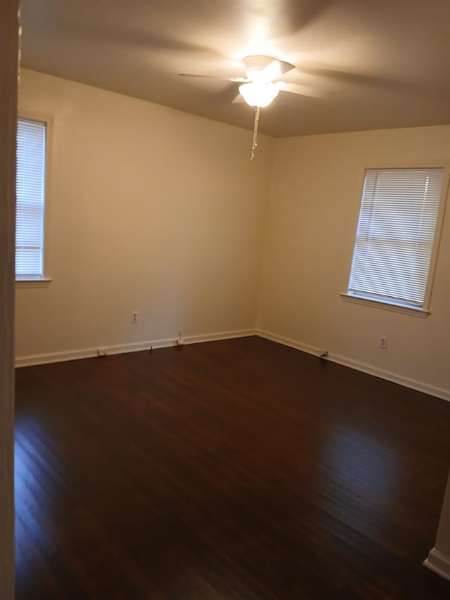 empty room with dark wood-type flooring and ceiling fan