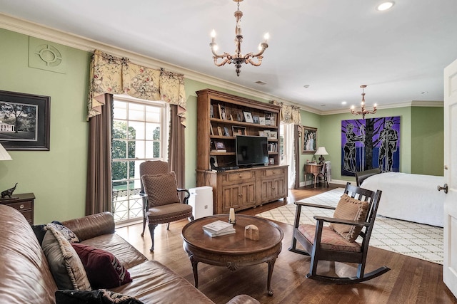 living room with a notable chandelier, hardwood / wood-style flooring, and crown molding