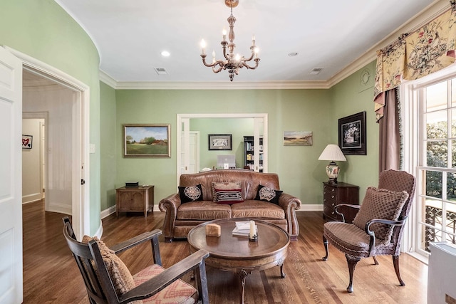 living room with ornamental molding, hardwood / wood-style flooring, and an inviting chandelier