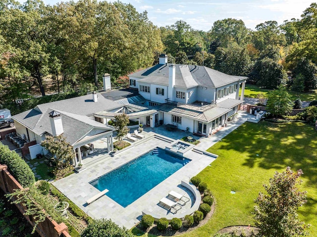 exterior space with a yard, a patio, and a pool with hot tub