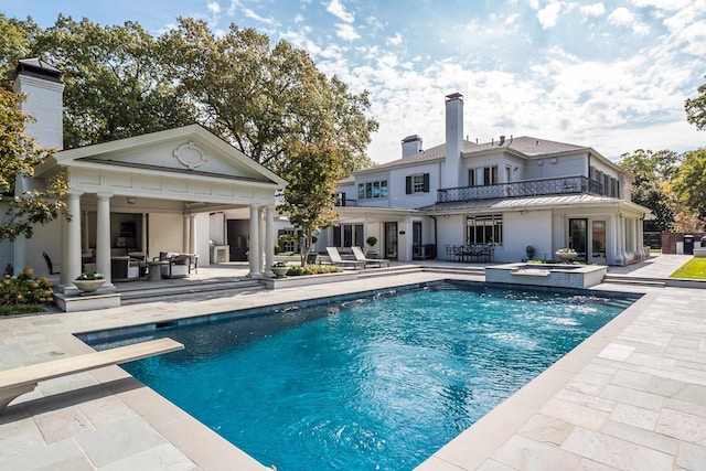 back of property featuring a balcony and a patio