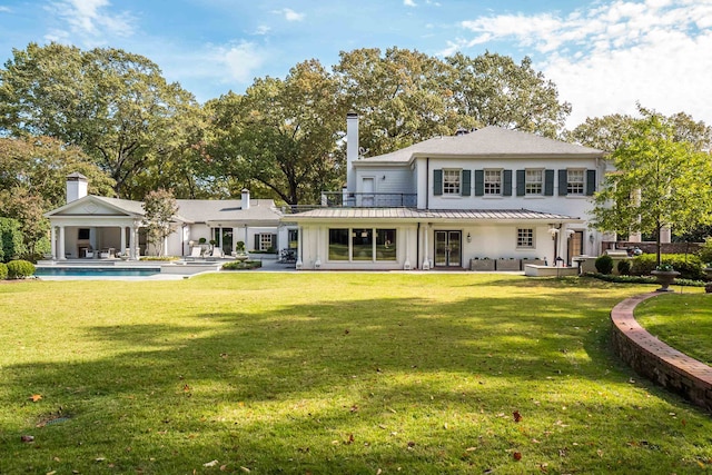 rear view of house featuring a yard and a patio