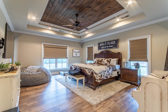 bedroom featuring crown molding, a tray ceiling, wood-type flooring, and ceiling fan