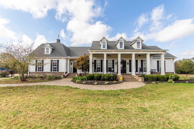 cape cod home with a front yard and a porch