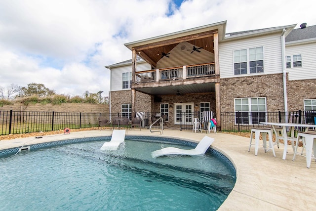 back of house with a fenced in pool, a balcony, a patio, and ceiling fan