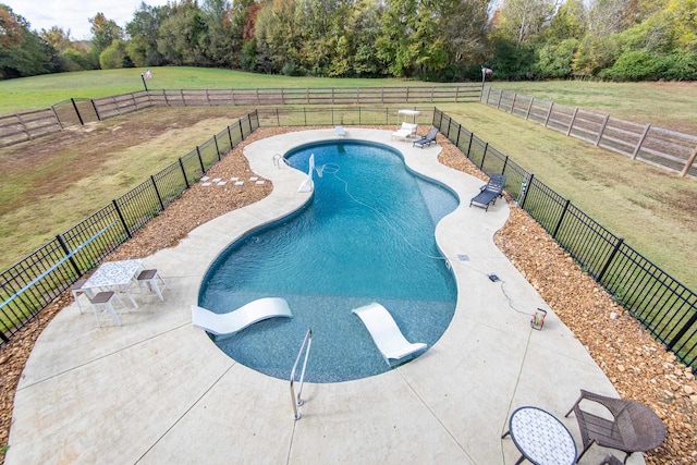 view of pool with a patio and a lawn