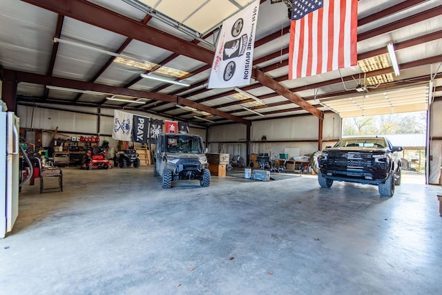 garage featuring white refrigerator and a carport