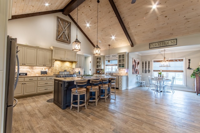 kitchen with a kitchen breakfast bar, a center island, light hardwood / wood-style flooring, and pendant lighting