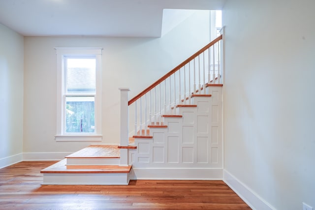 stairs featuring hardwood / wood-style floors