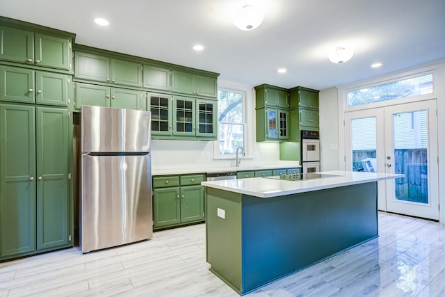 kitchen featuring a kitchen island, stainless steel appliances, green cabinets, and french doors