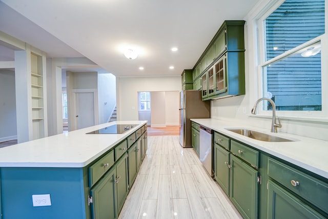 kitchen with green cabinets, sink, a center island, light wood-type flooring, and appliances with stainless steel finishes