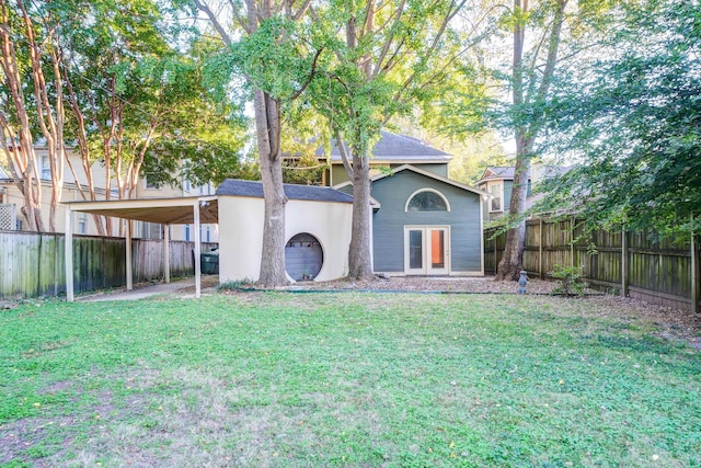 back of property with french doors and a yard