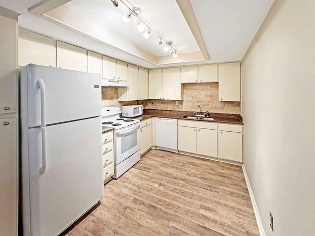 kitchen featuring cream cabinets, tasteful backsplash, a raised ceiling, light wood-type flooring, and white appliances