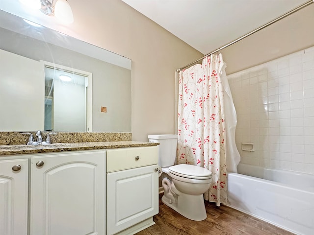 full bathroom featuring hardwood / wood-style floors, shower / bath combo, vanity, and toilet