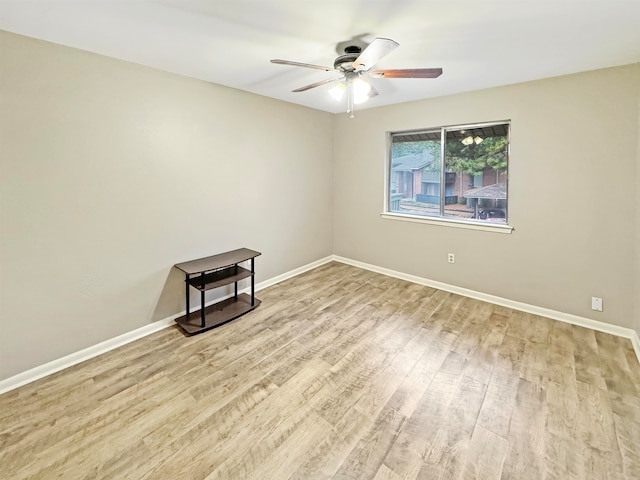 empty room with ceiling fan and light hardwood / wood-style flooring