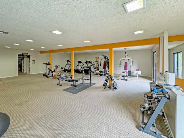 workout area with a textured ceiling and light carpet