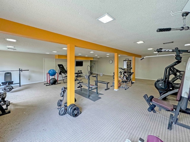 exercise room with a textured ceiling and carpet