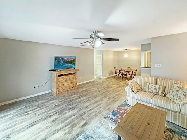 living room featuring ceiling fan and light hardwood / wood-style flooring