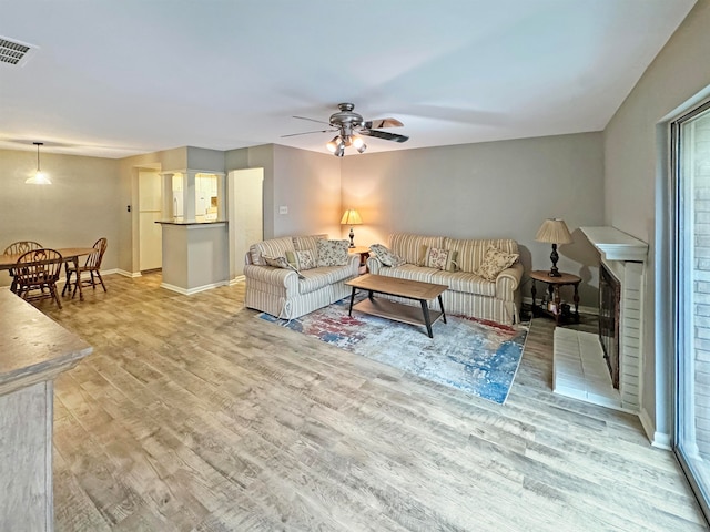 living room with light hardwood / wood-style floors and ceiling fan