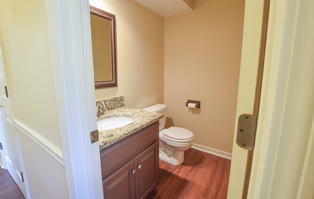 bathroom with vanity, toilet, and wood-type flooring