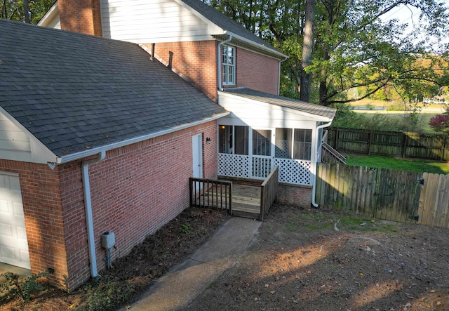 back of property with a garage and a sunroom