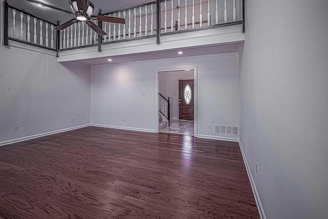 unfurnished living room featuring ceiling fan and dark hardwood / wood-style flooring