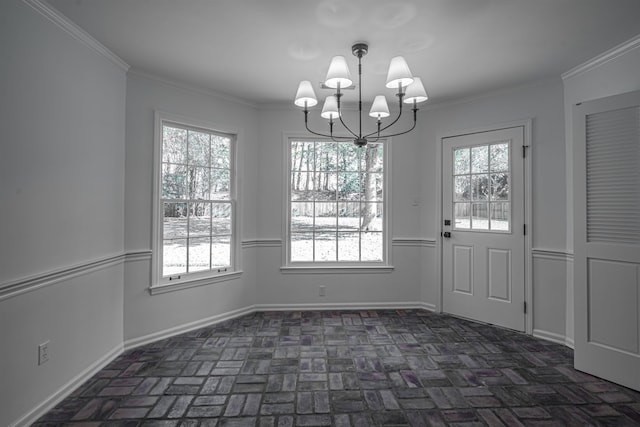 unfurnished dining area with an inviting chandelier, crown molding, and a healthy amount of sunlight