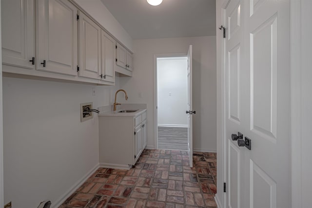 washroom with cabinets, hookup for a washing machine, and sink