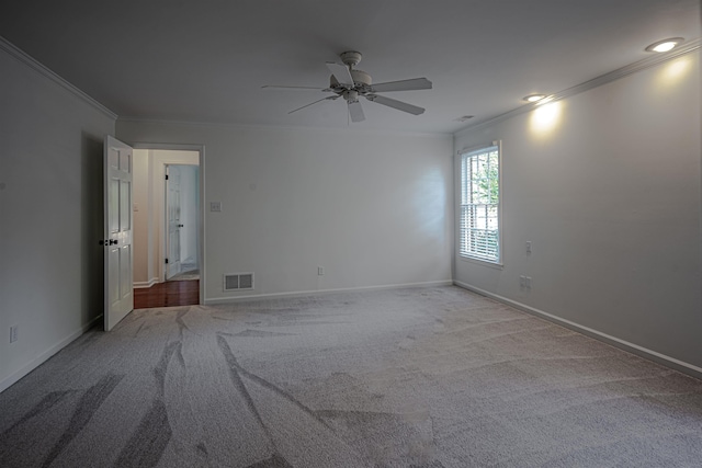 carpeted spare room featuring ornamental molding and ceiling fan