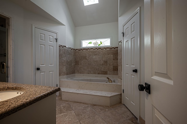 bathroom featuring vanity, lofted ceiling, tile patterned flooring, and a bathing tub