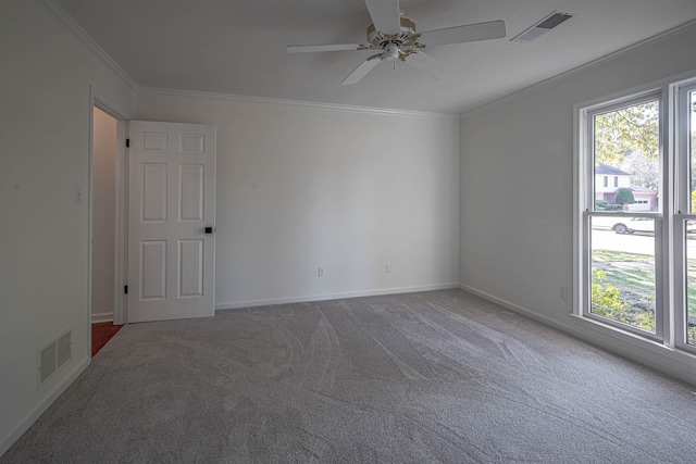 spare room featuring crown molding, carpet flooring, and ceiling fan